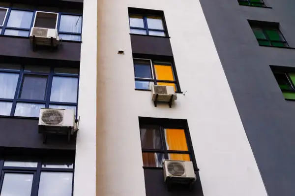 Klimatyzacja w bloku, zamontowana na ścianie z oknami, zapewnia komfortowe warunki.